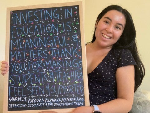 Aurora, UX research operations specialist, holding message of gratitude